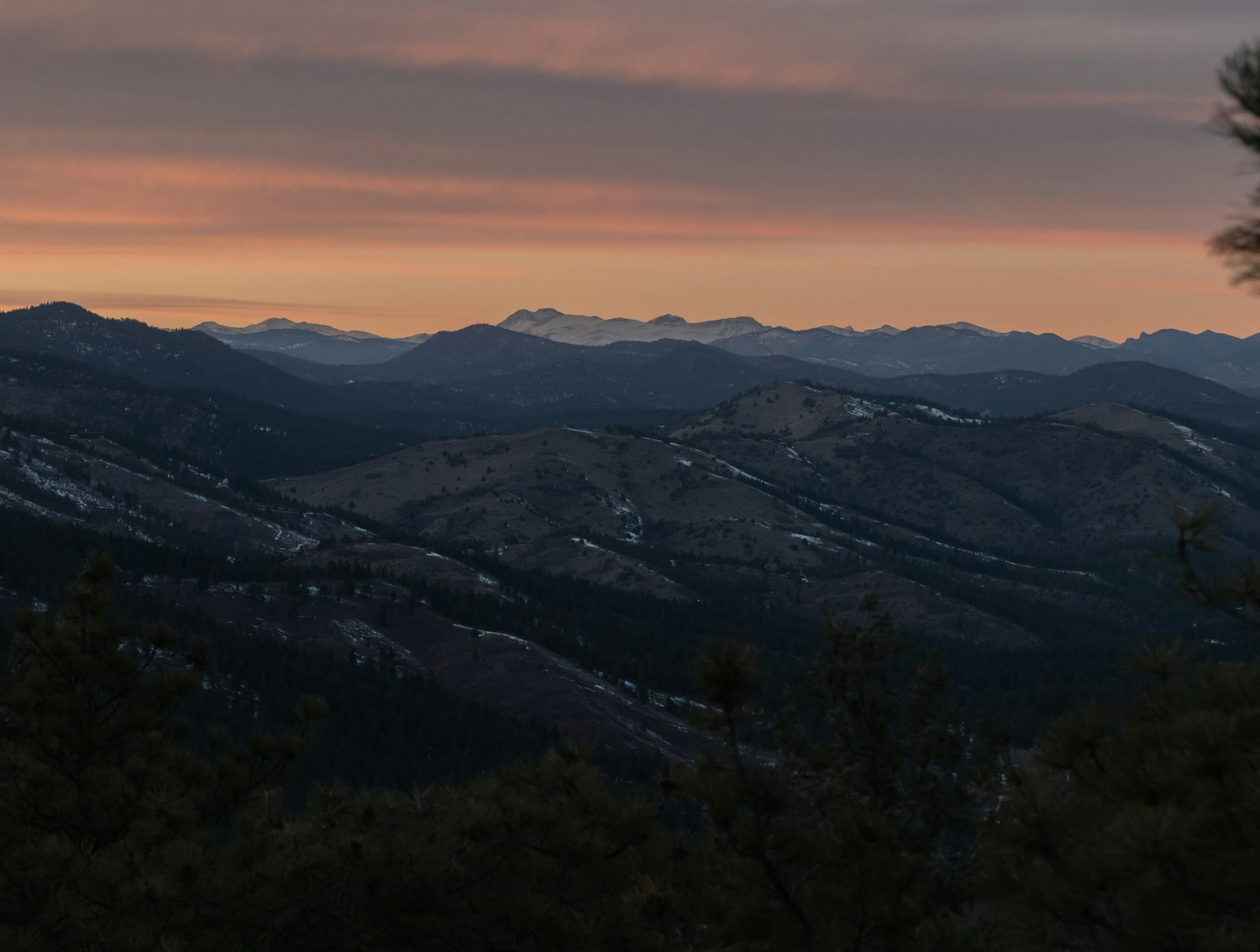 Front Range Colorado mountains at dusk, pink sky above silhouetted ridgeline